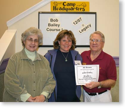 Terry Ryan, Ali Brown and Bob Bailey pose with Ali's graduation certificate